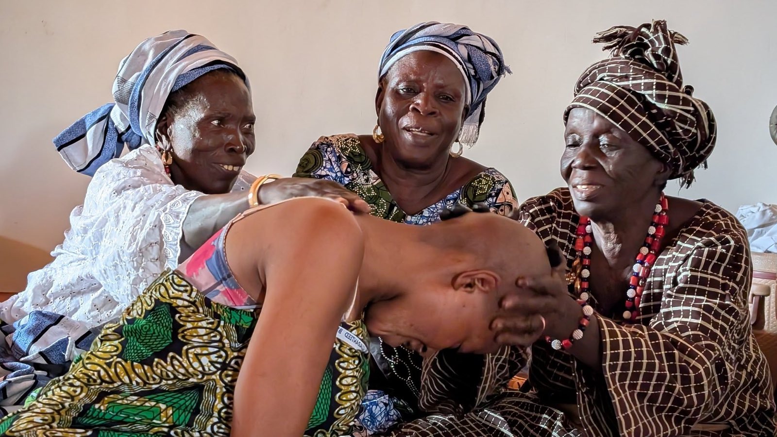 Le rasage rituel d\u2019un enfant, entouré des femmes de la cour.